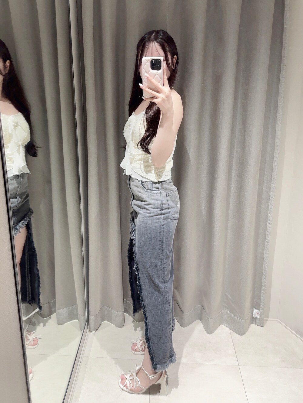 ブラック系のデニムスカート、ホワイト系のキャミソール、ホワイト系のサンダルを着用したレディースの夏コーディネートの3枚目の写真