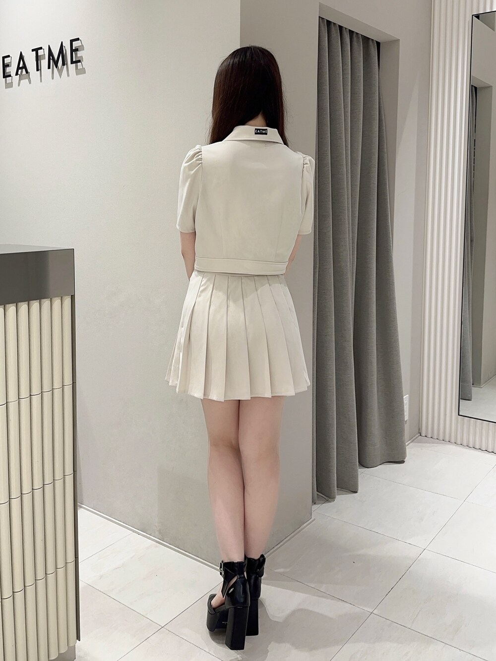 ホワイト系のスカート、ホワイト系のシャツ/ブラウス、ブラック系のパンプスを着用したレディースの夏コーディネートの3枚目の写真