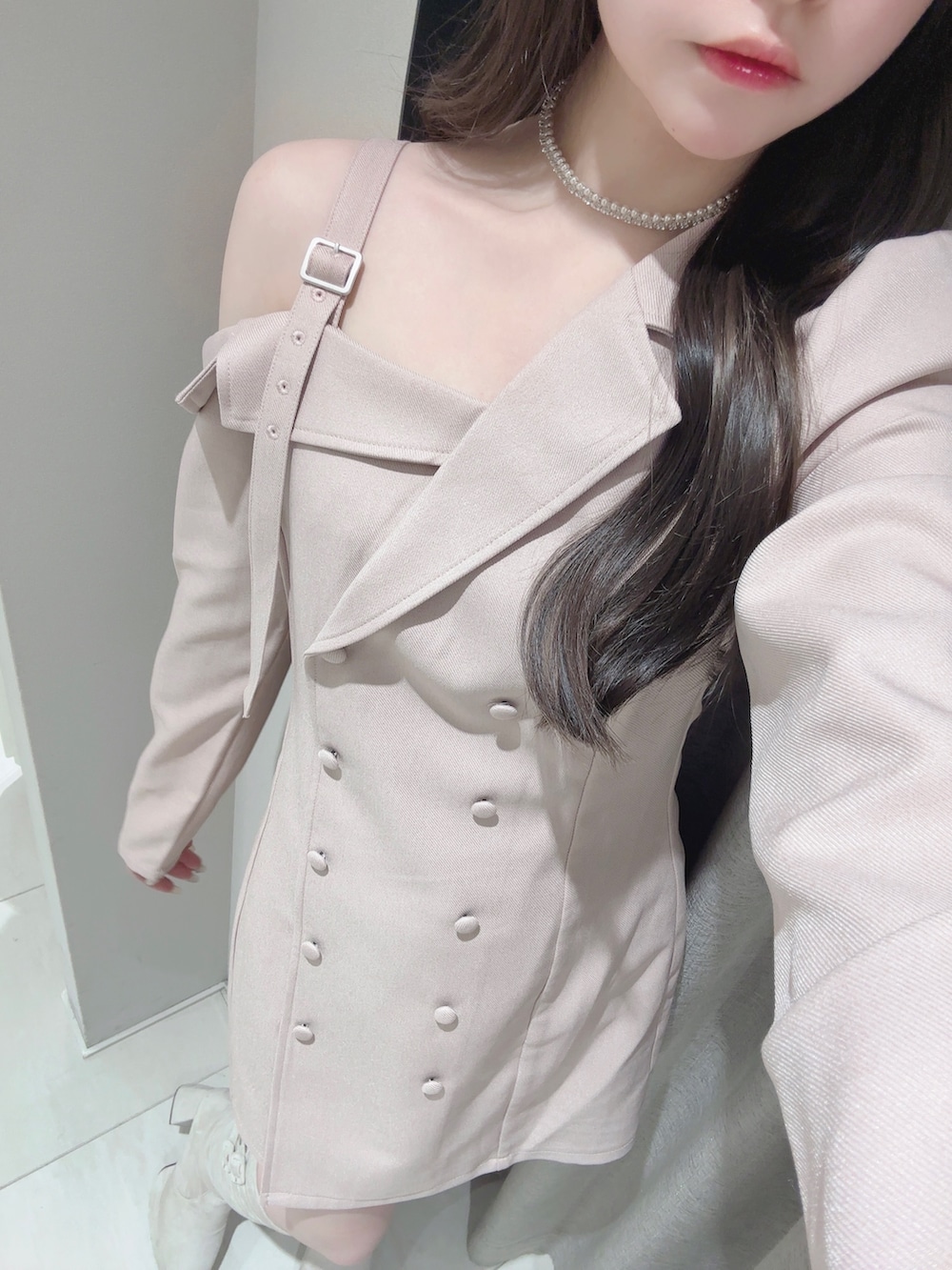 ピンク系のワンピース、ホワイト系のブーツ、シルバー系のネックレスを着用したレディースの冬コーディネートの5枚目の写真