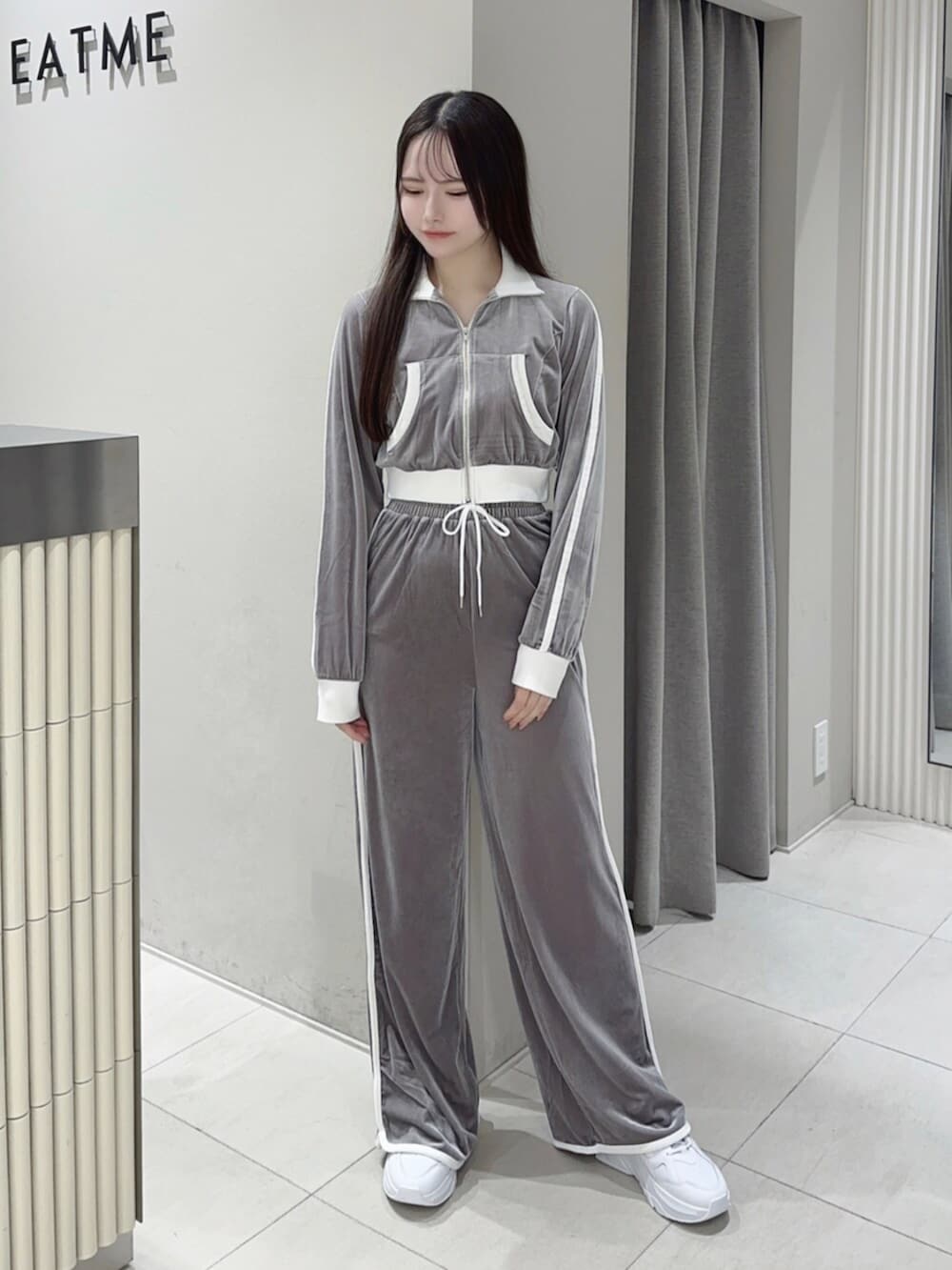 ホワイト系のスニーカー、グレー系のその他パンツ、グレー系のブルゾンを着用したレディースの秋コーディネートの2枚目の写真