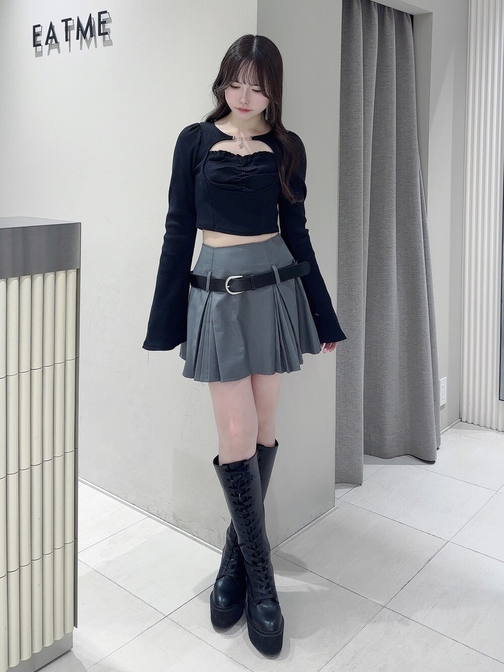 ブラック系のTシャツ/カットソー、グレー系のスカート、ブラック系のブーツを着用したレディースの冬コーディネートの2枚目の写真