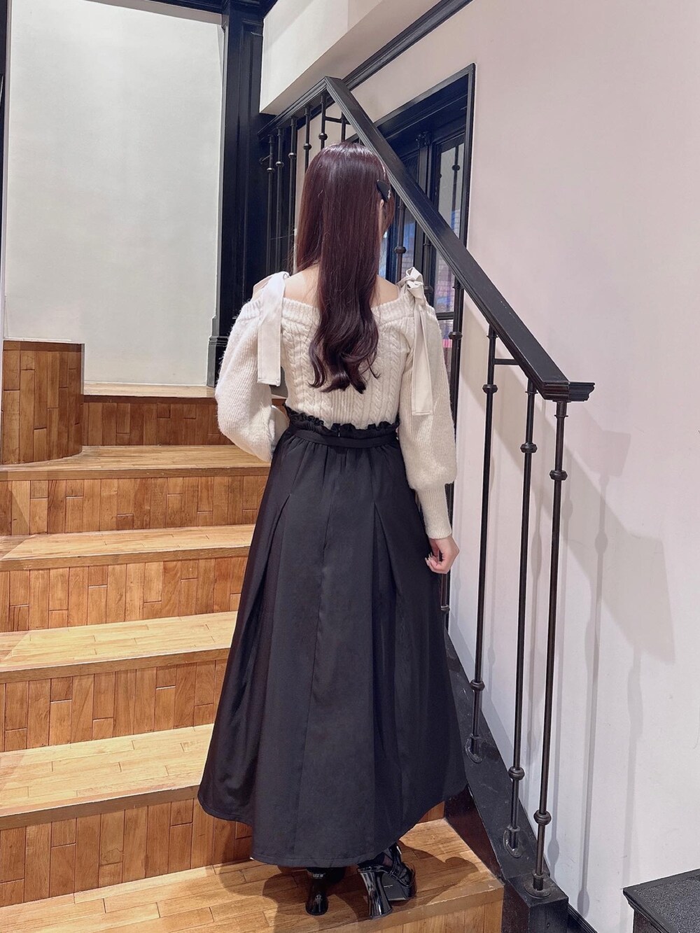ホワイト系のニット/セーター、ブラック系のパンプス、ブラック系のジャンパースカートを着用したレディースの秋コーディネートの3枚目の写真