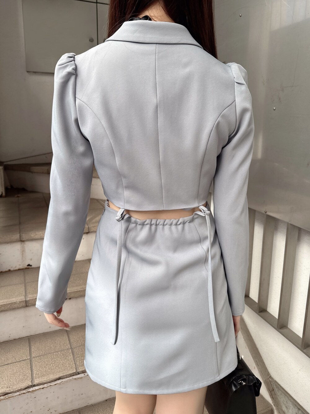 ブルー系のワンピース、ブラック系のショルダーバッグ、その他のパンプスを着用したレディースの冬コーディネートの7枚目の写真