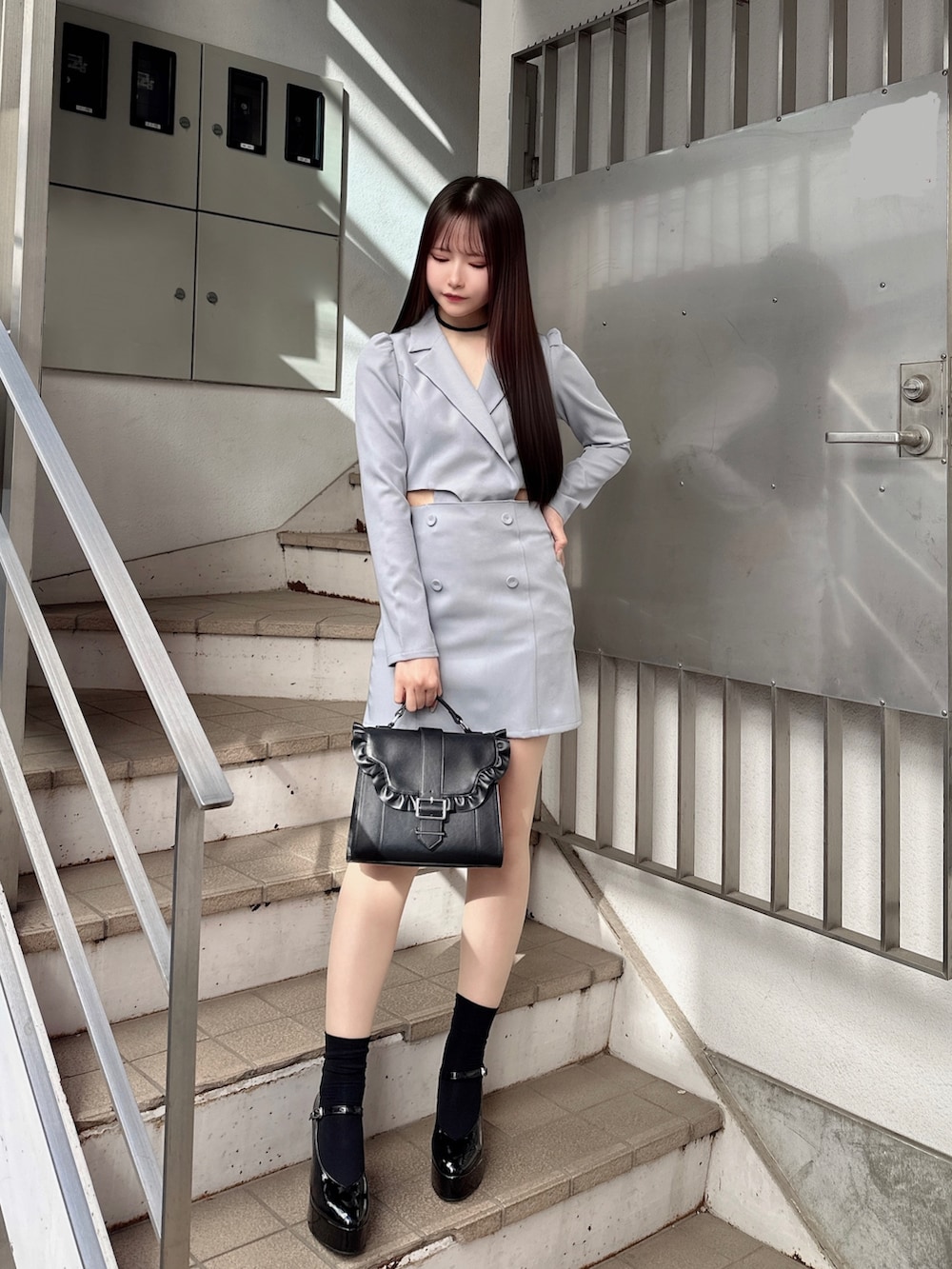 ブルー系のワンピース、ブラック系のショルダーバッグ、その他のパンプスを着用したレディースの冬コーディネートの2枚目の写真