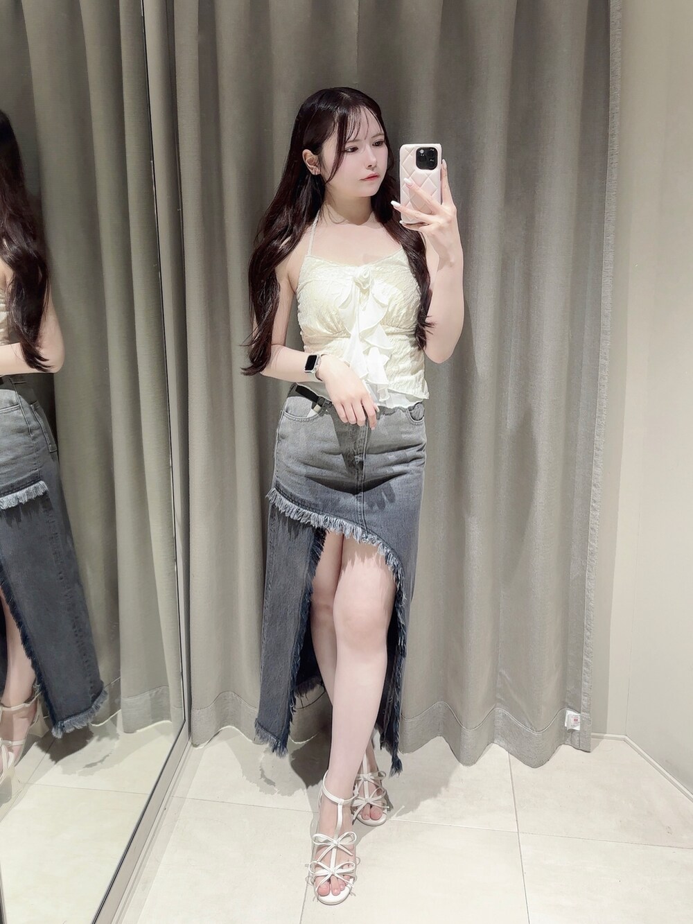 ブラック系のデニムスカート、ホワイト系のキャミソール、ホワイト系のサンダルを着用したレディースの夏コーディネートの2枚目の写真