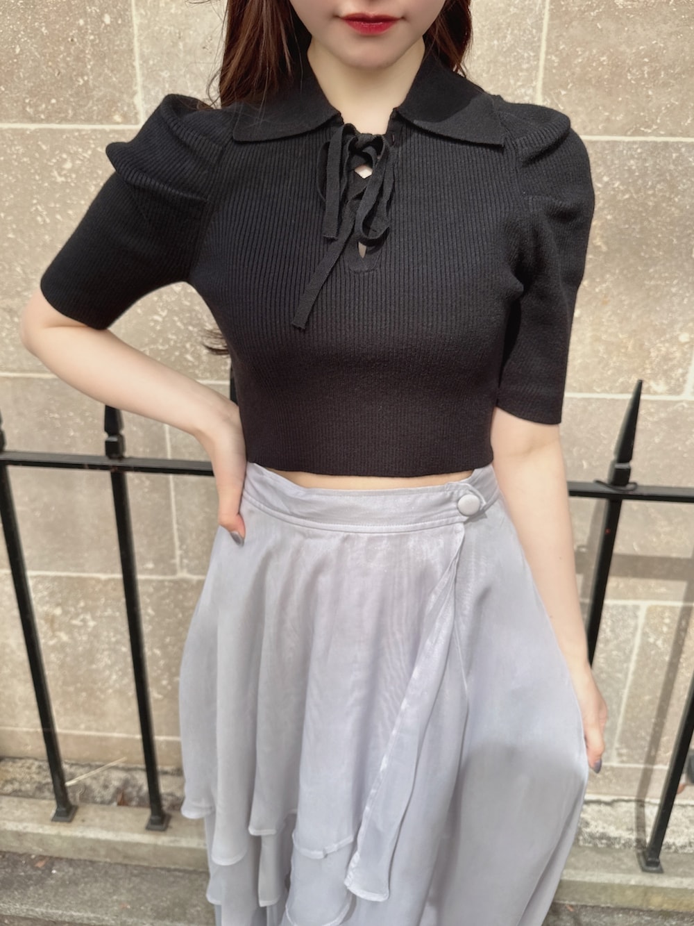 ブラック系のニット/セーター、グレー系のスカート、ブラック系のショルダーバッグを着用したレディースの春コーディネートの4枚目の写真