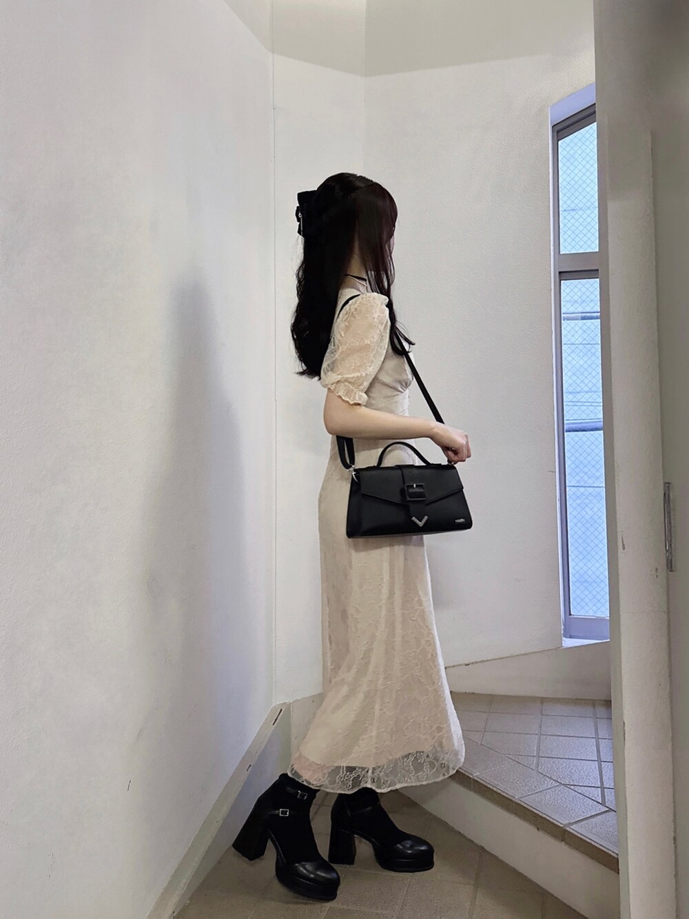 ベージュ系のワンピース、ブラック系のショルダーバッグ、ブラック系のパンプスを着用したレディースの夏コーディネートの3枚目の写真