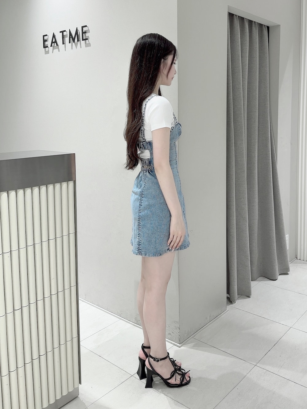 ブルー系のワンピース、ホワイト系のTシャツ/カットソー、ブラック系のサンダルを着用したレディースの夏コーディネートの3枚目の写真