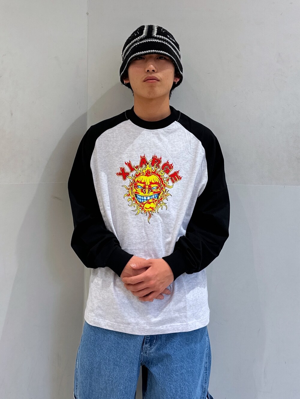 ブラック系のTシャツ/カットソー、ブルー系のデニムパンツ、ブラック系のハットを着用したメンズの春コーディネートの5枚目の写真