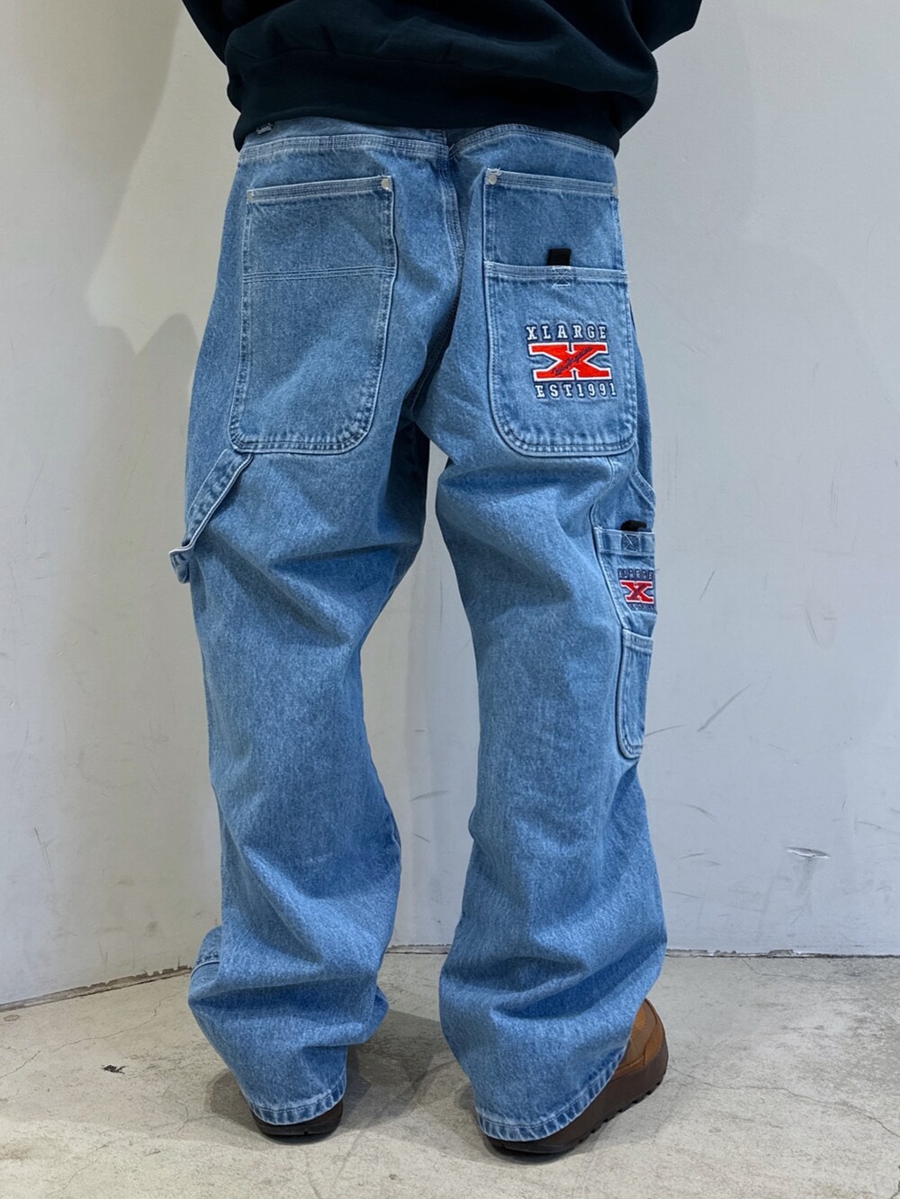 ブラック系のTシャツ/カットソー、ブルー系のデニムパンツ、ブラック系のハットを着用したメンズの春コーディネートの6枚目の写真