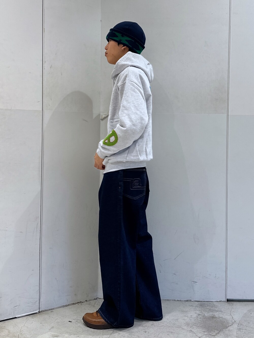 グレー系のパーカー、ブルー系のデニムパンツ、ブルー系のニットキャップ/ビーニーを着用したメンズの冬コーディネートの2枚目の写真