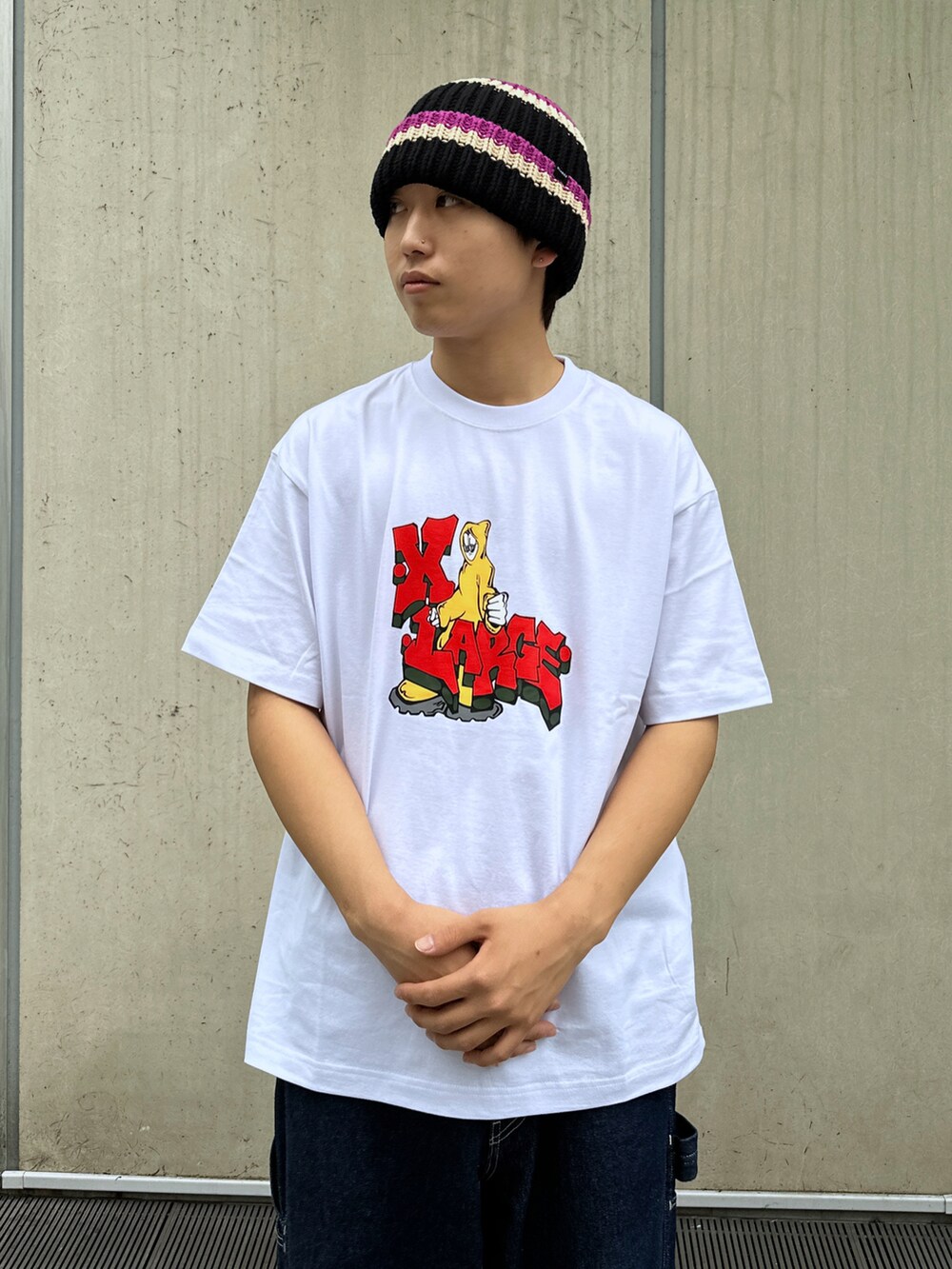 ホワイト系のTシャツ/カットソー、ブルー系のデニムパンツ、ブラック系のニットキャップ/ビーニーを着用したメンズの春コーディネートの5枚目の写真