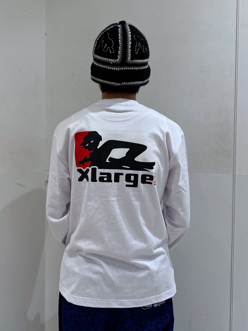 ホワイト系のTシャツ/カットソー、ブルー系のその他パンツ、ブラック系のハットを着用したメンズの冬コーディネートの5枚目の写真