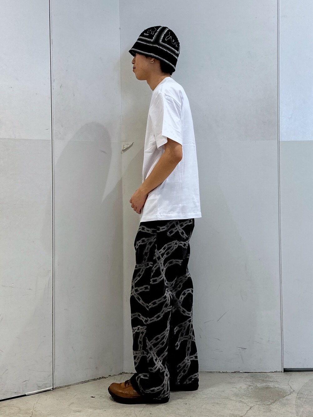 ホワイト系のTシャツ/カットソー、ブラック系のデニムパンツ、ブラック系のハットを着用したメンズの春コーディネートの2枚目の写真