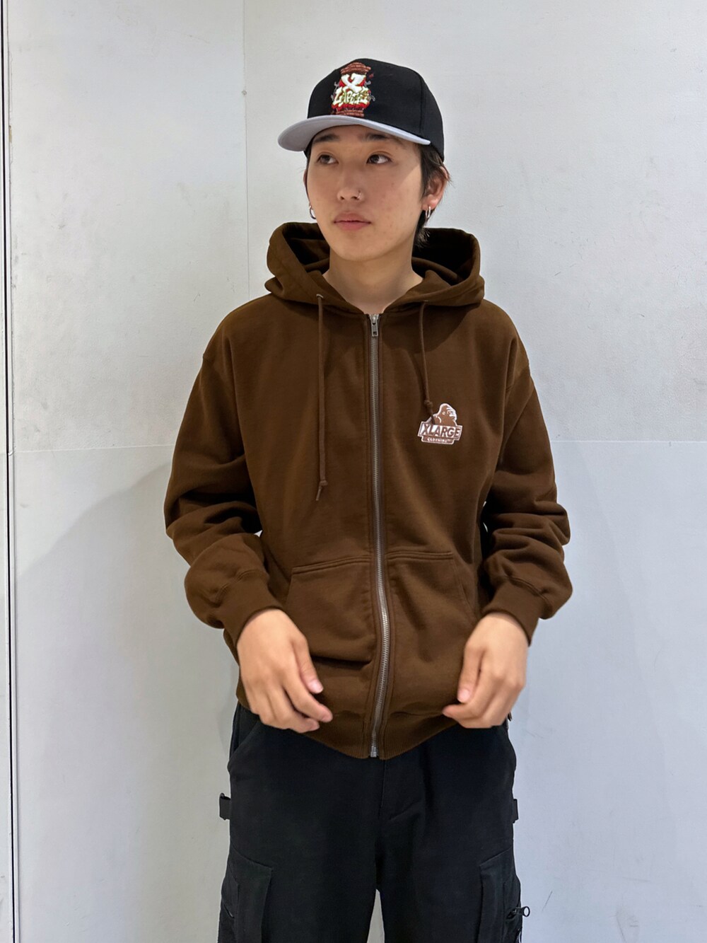 ブラウン系のパーカー、ブラック系のその他パンツ、ブラック系のキャップを着用したメンズの秋コーディネートの5枚目の写真