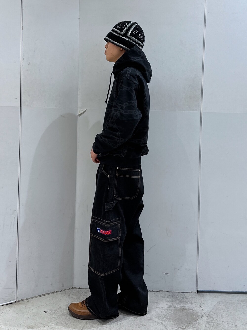 ブラック系のパーカー、ブラック系のデニムパンツ、ブラック系のハットを着用したメンズの春コーディネートの2枚目の写真