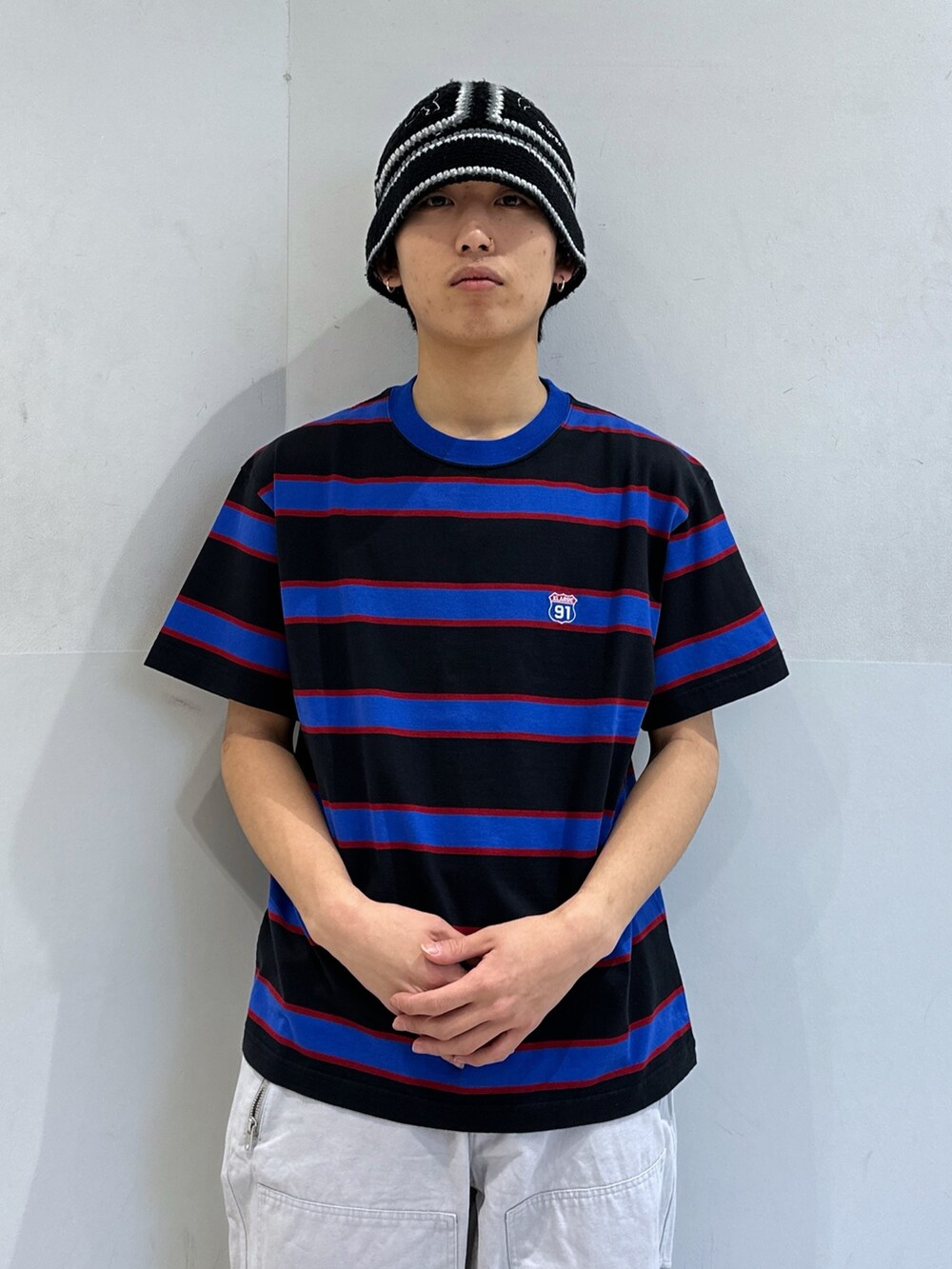 ブルー系のTシャツ/カットソー、グレー系のその他パンツ、ブラック系のハットを着用したメンズの春コーディネートの5枚目の写真