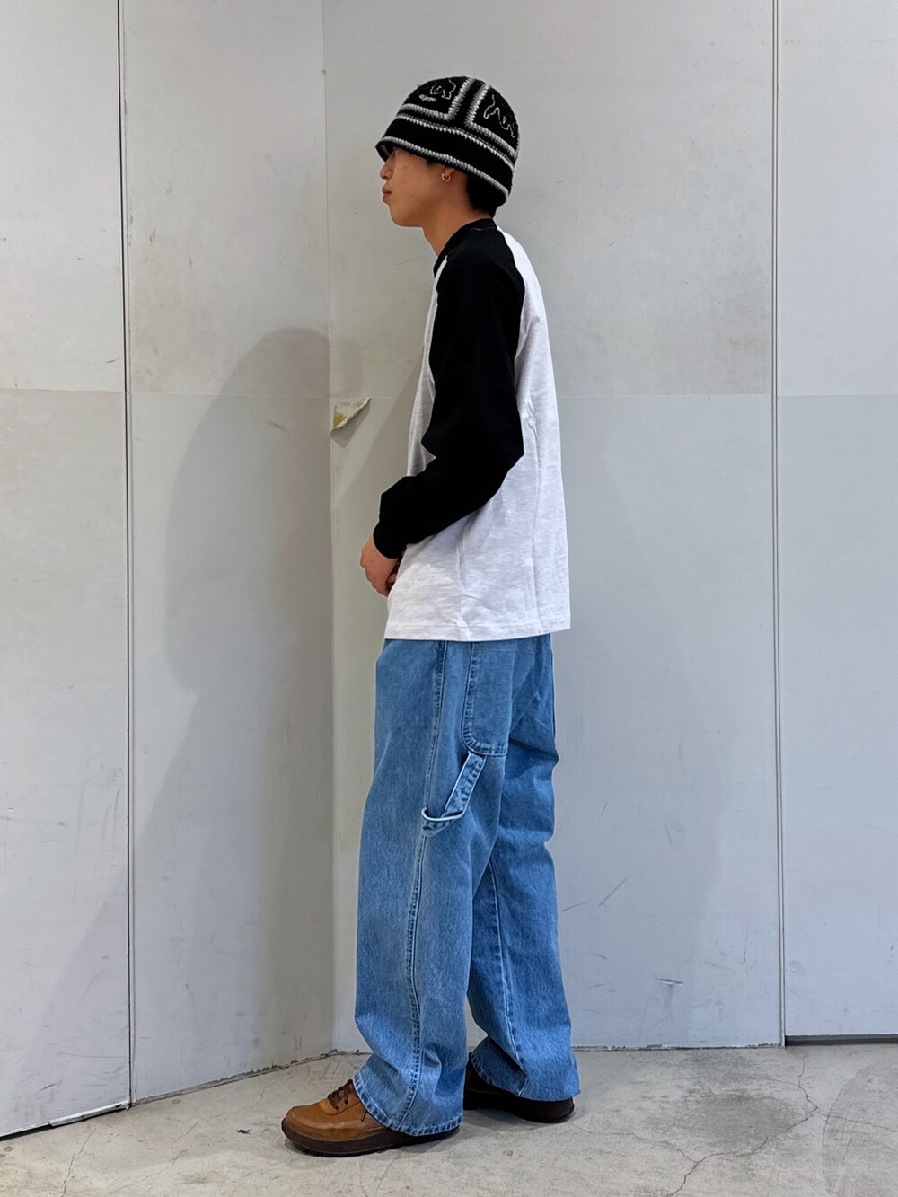 ブラック系のTシャツ/カットソー、ブルー系のデニムパンツ、ブラック系のハットを着用したメンズの春コーディネートの2枚目の写真