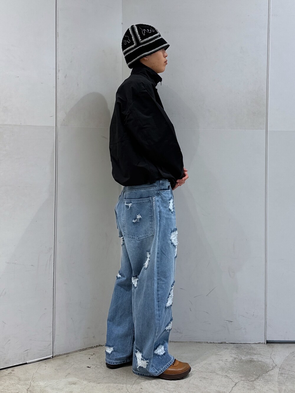 ブラック系のブルゾン、ブルー系のデニムパンツ、ブラック系のハットを着用したメンズの春コーディネートの4枚目の写真