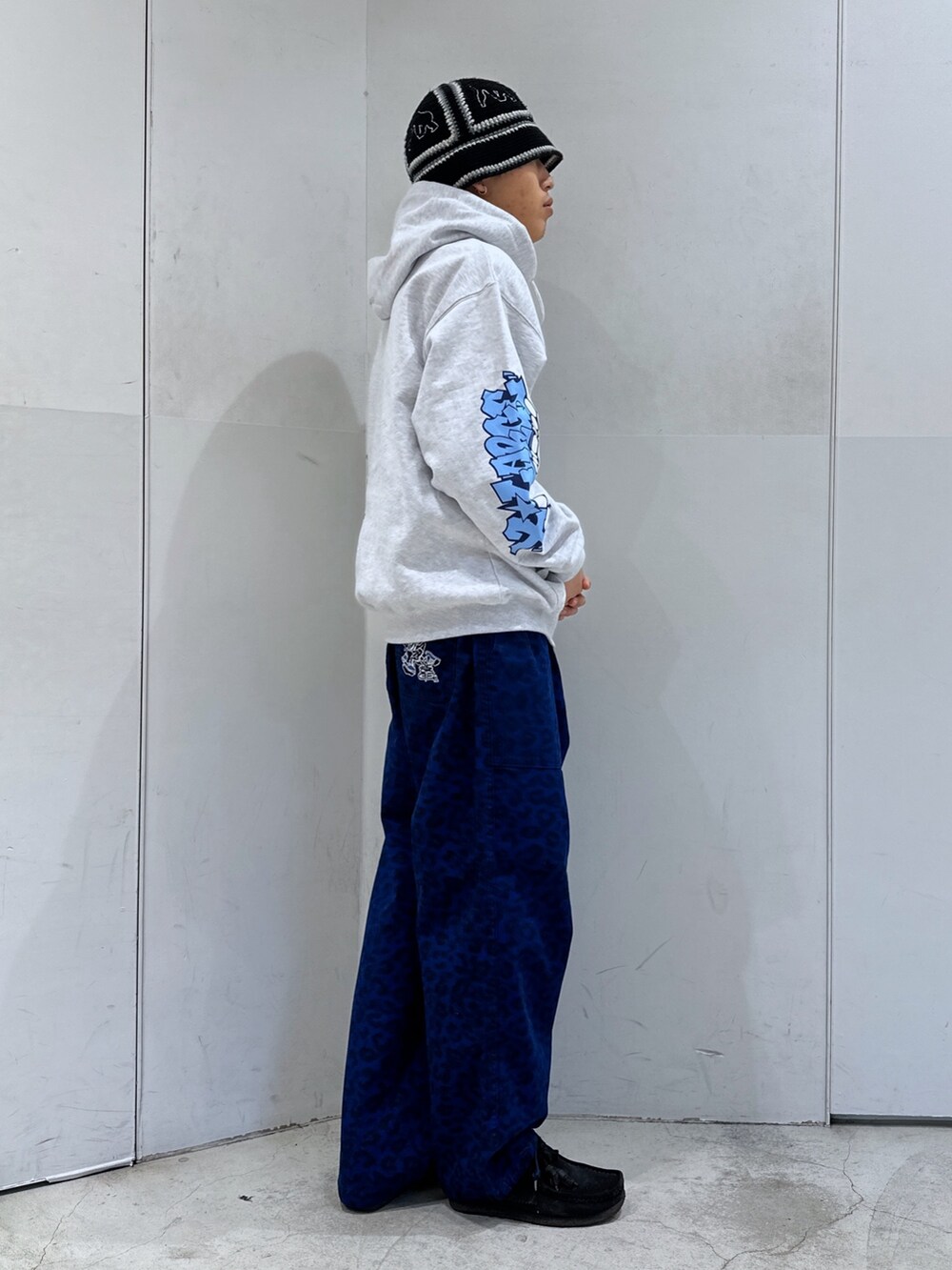 グレー系のパーカー、ブルー系のその他パンツを着用したメンズの冬コーディネートの4枚目の写真