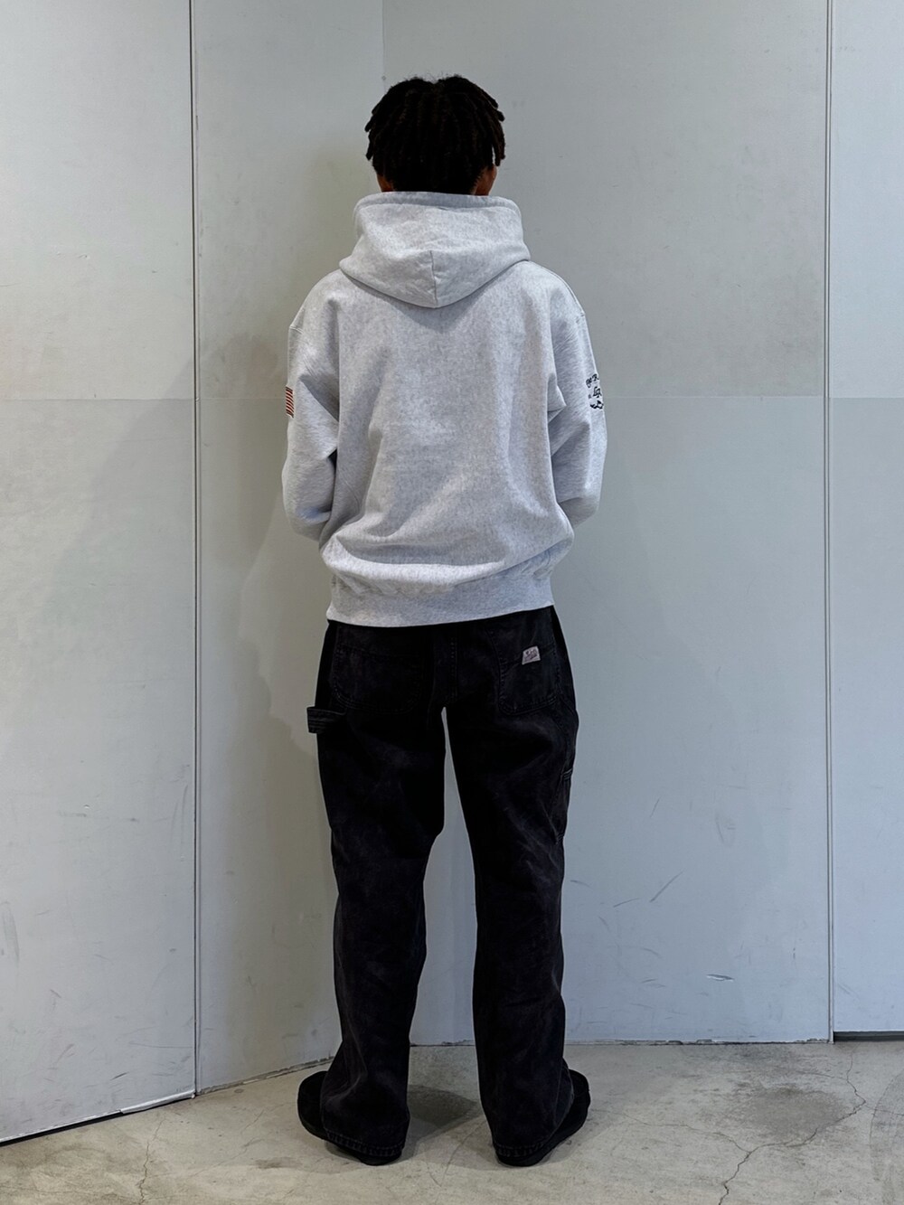 グレー系のパーカー、ブラック系のその他パンツを着用したメンズの秋コーディネートの3枚目の写真