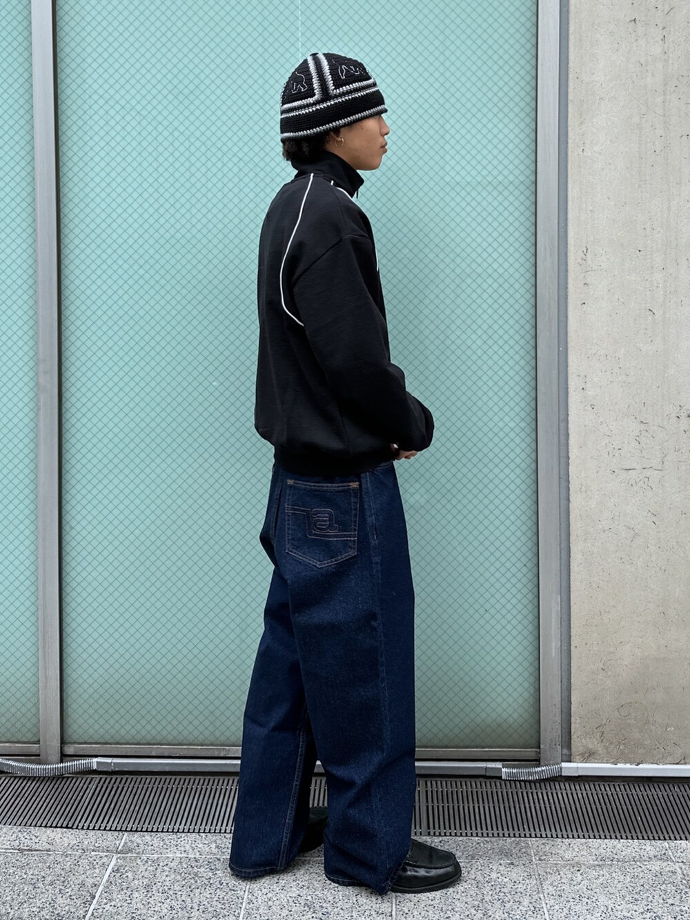 ブラック系のスウェット、ブルー系のデニムパンツを着用したメンズの冬コーディネートの4枚目の写真