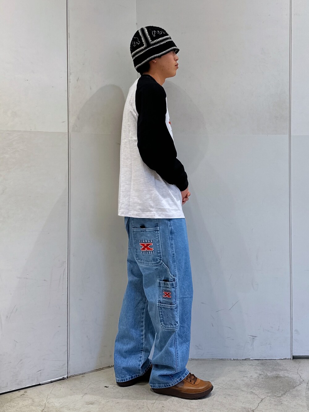 ブラック系のTシャツ/カットソー、ブルー系のデニムパンツ、ブラック系のハットを着用したメンズの春コーディネートの4枚目の写真