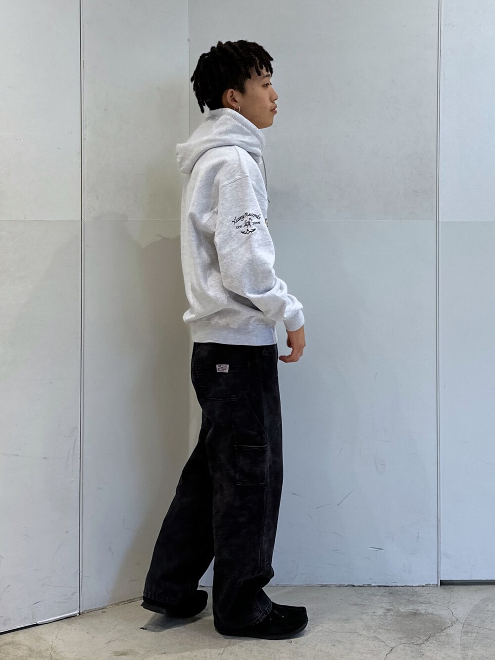 グレー系のパーカー、ブラック系のその他パンツを着用したメンズの秋コーディネートの4枚目の写真