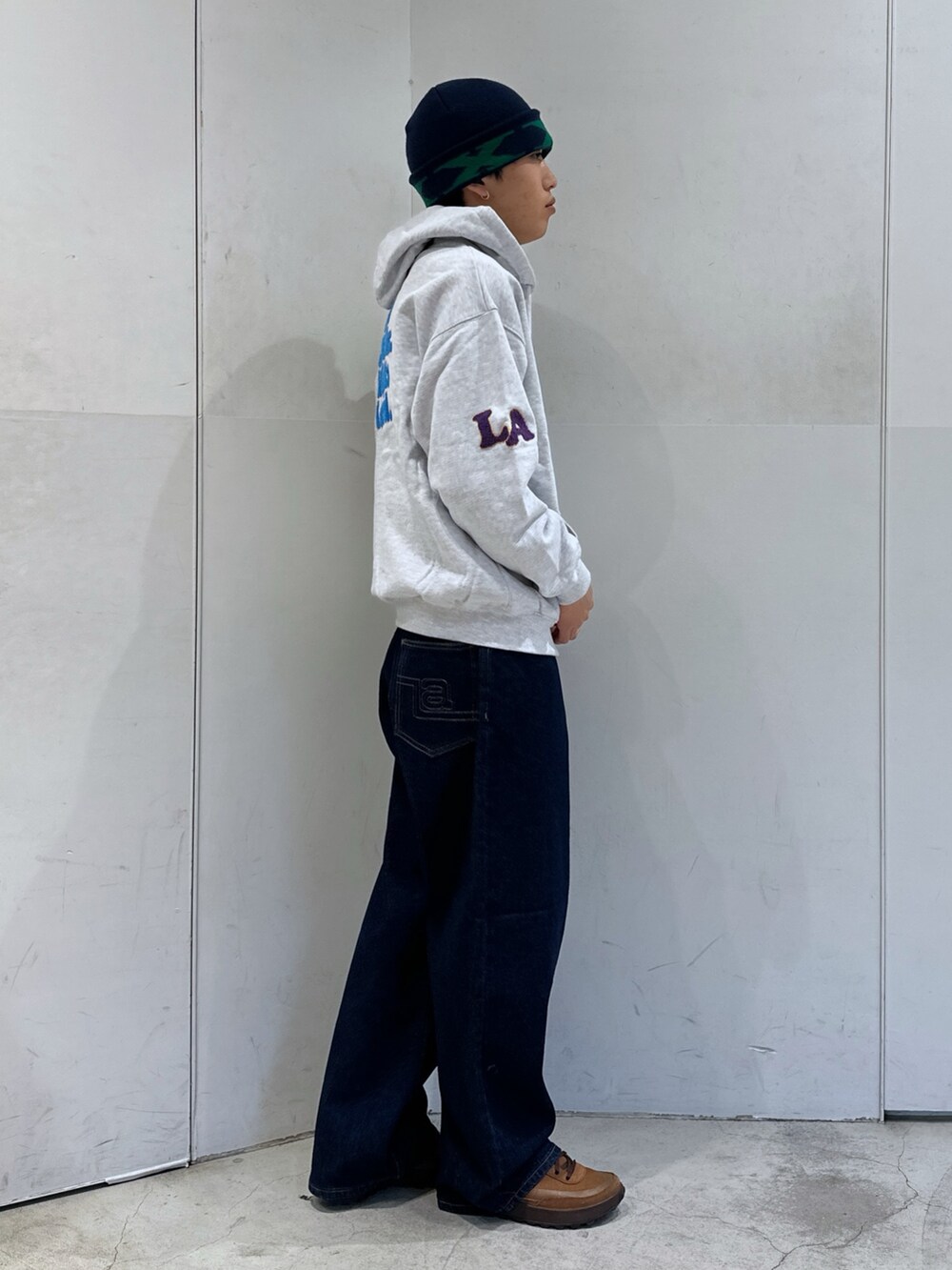グレー系のパーカー、ブルー系のデニムパンツ、ブルー系のニットキャップ/ビーニーを着用したメンズの冬コーディネートの4枚目の写真