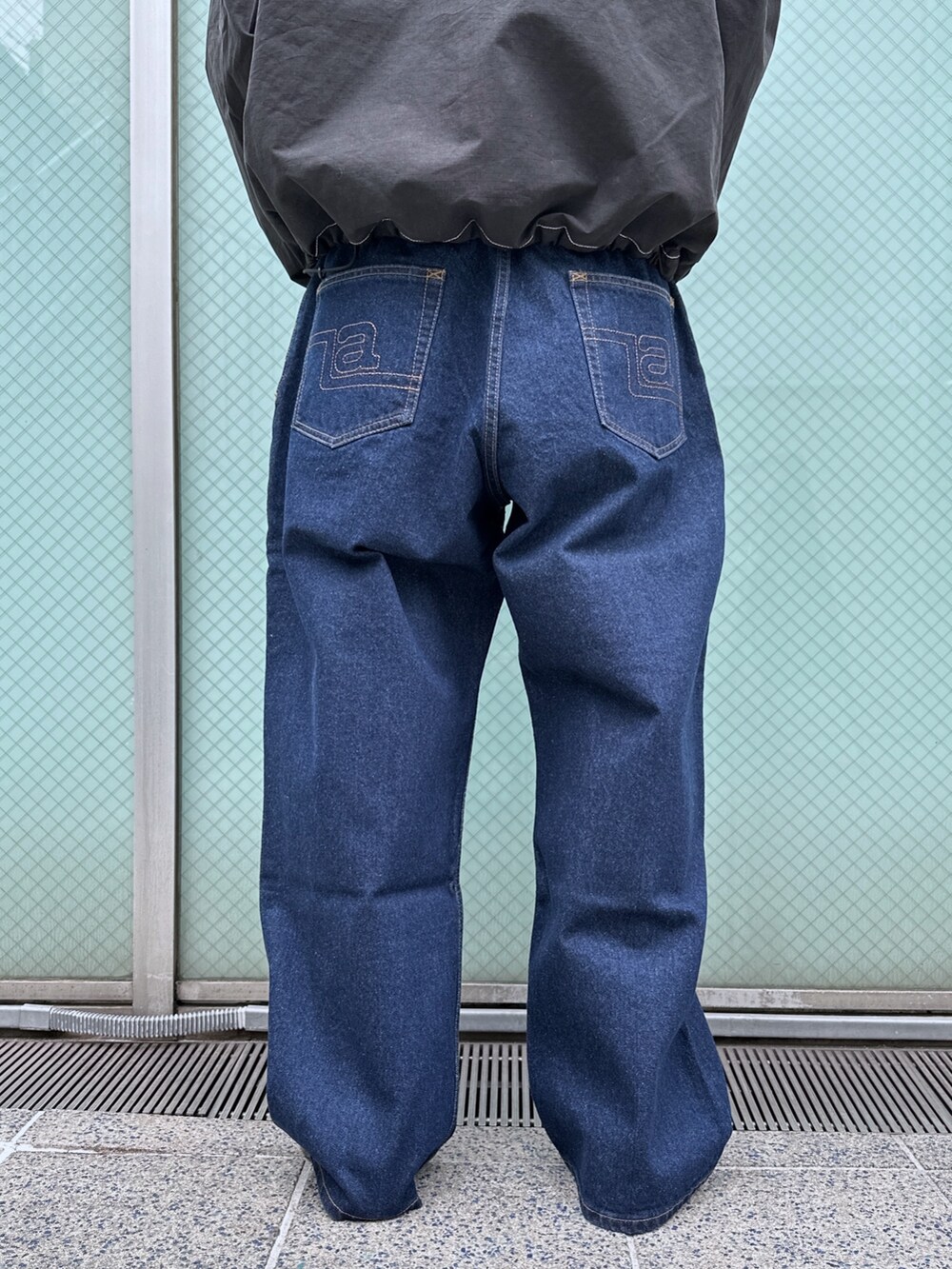 ブラック系のスウェット、ブルー系のデニムパンツを着用したメンズの冬コーディネートの6枚目の写真