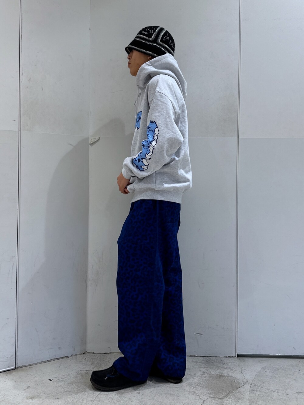 グレー系のパーカー、ブルー系のその他パンツを着用したメンズの冬コーディネートの2枚目の写真