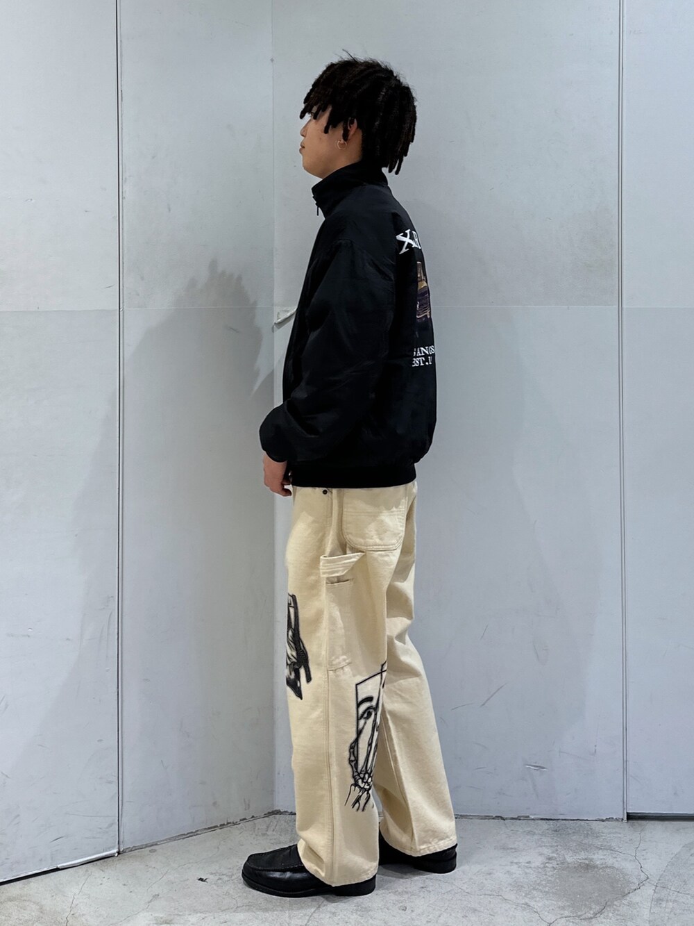 ブラック系のブルゾン、ベージュ系のその他パンツを着用したメンズの冬コーディネートの2枚目の写真