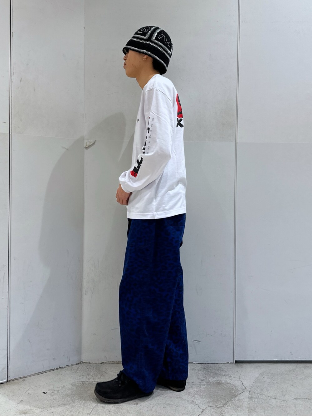 ホワイト系のTシャツ/カットソー、ブルー系のその他パンツ、ブラック系のハットを着用したメンズの冬コーディネートの2枚目の写真