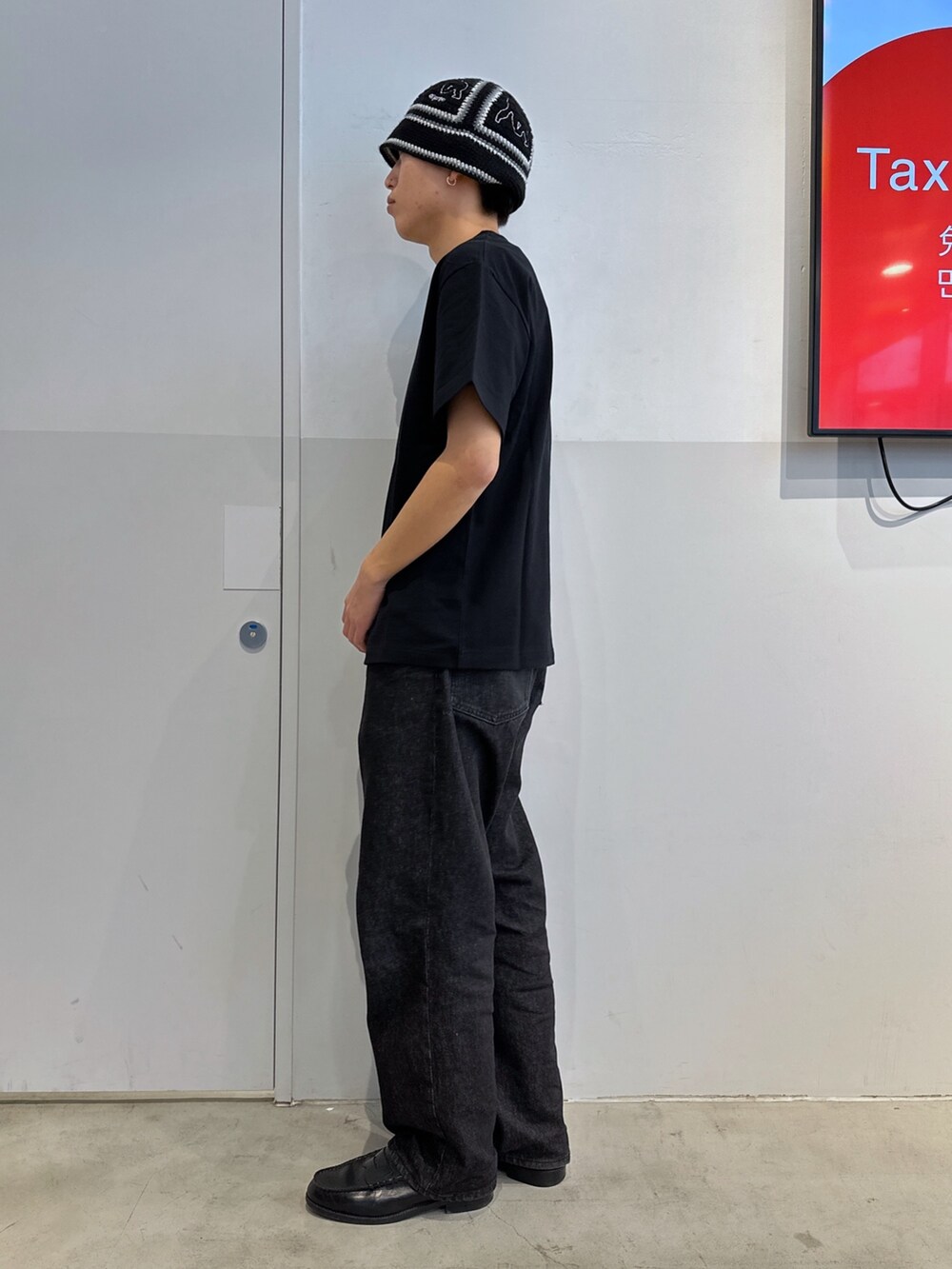 ブラック系のTシャツ/カットソー、ブラック系のデニムパンツ、ブラック系のハットを着用したメンズの冬コーディネートの2枚目の写真