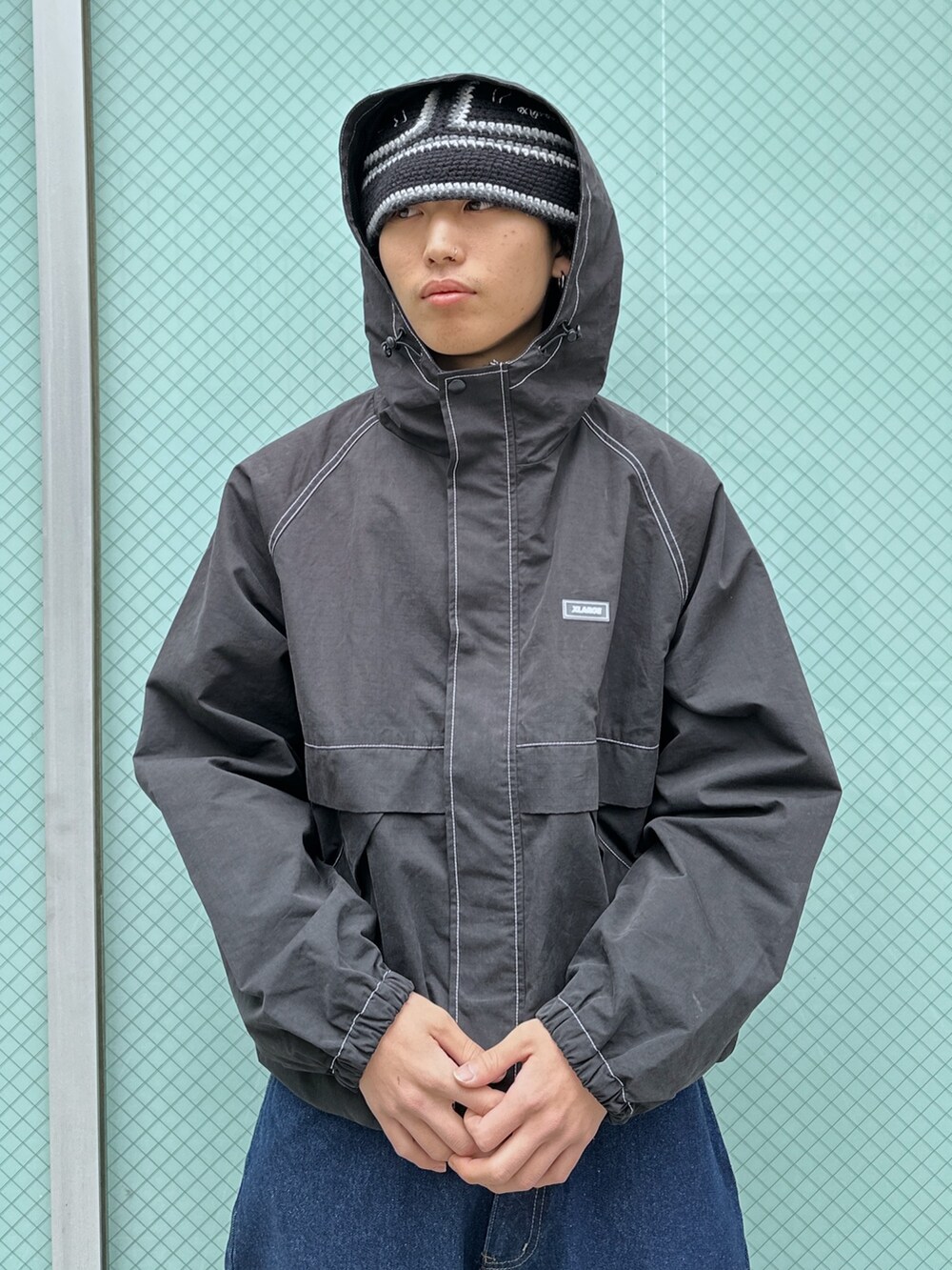 ブラック系のブルゾン、ブルー系のデニムパンツを着用したメンズの冬コーディネートの5枚目の写真