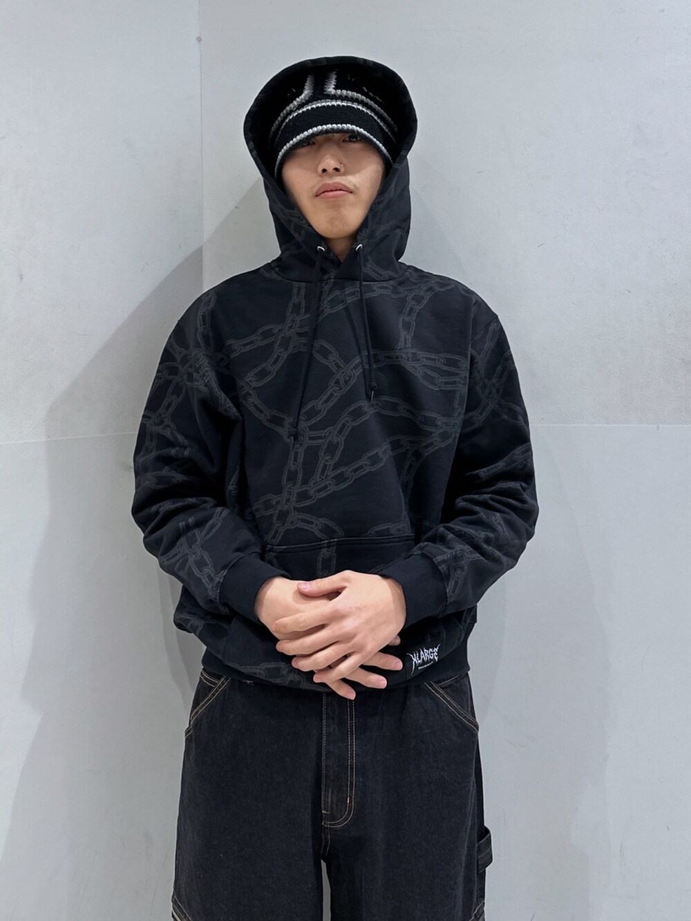 ブラック系のパーカー、ブラック系のデニムパンツ、ブラック系のハットを着用したメンズの春コーディネートの5枚目の写真