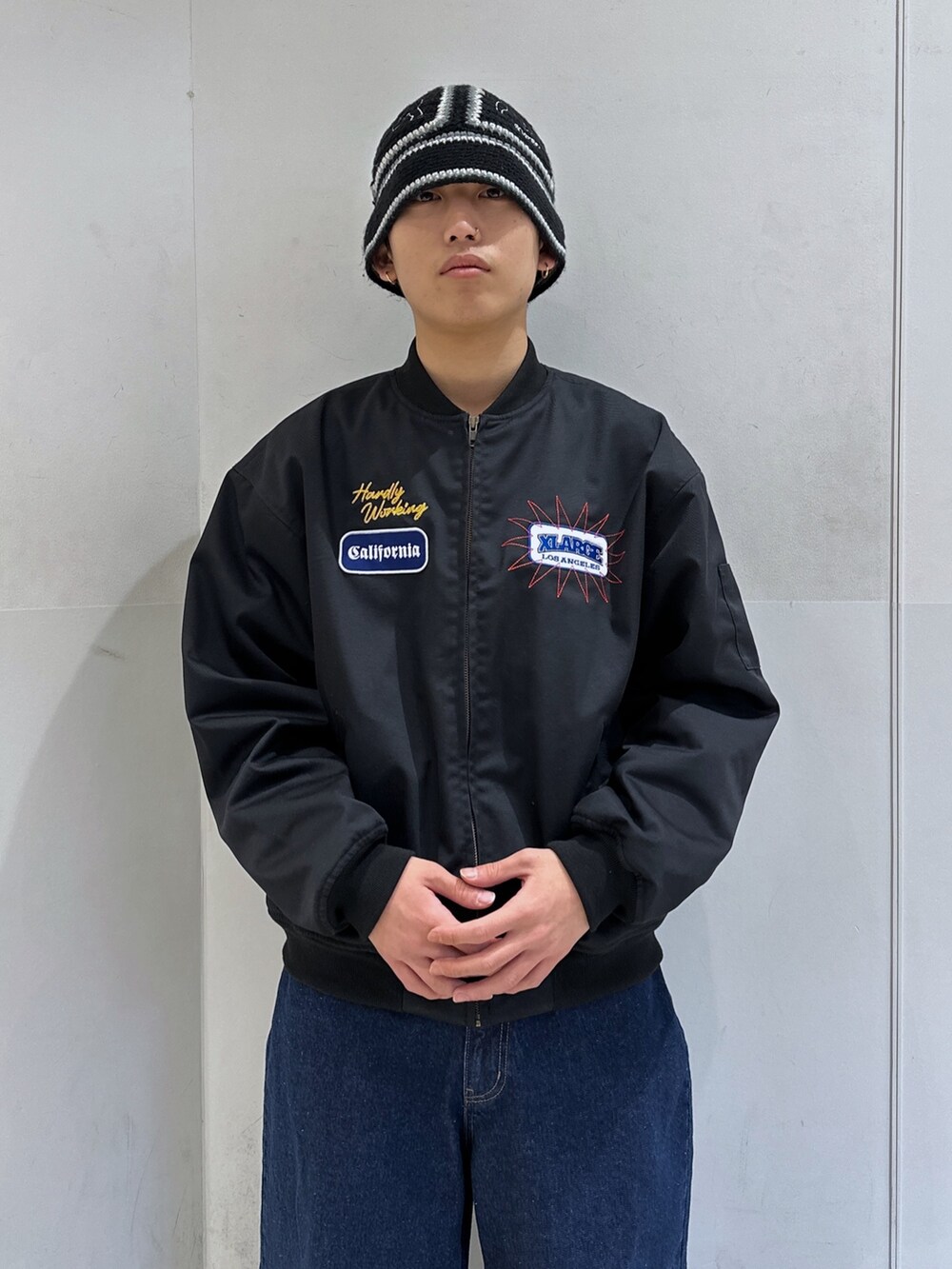 ブラック系のブルゾン、ブルー系のデニムパンツ、ブラック系のハットを着用したメンズの冬コーディネートの5枚目の写真