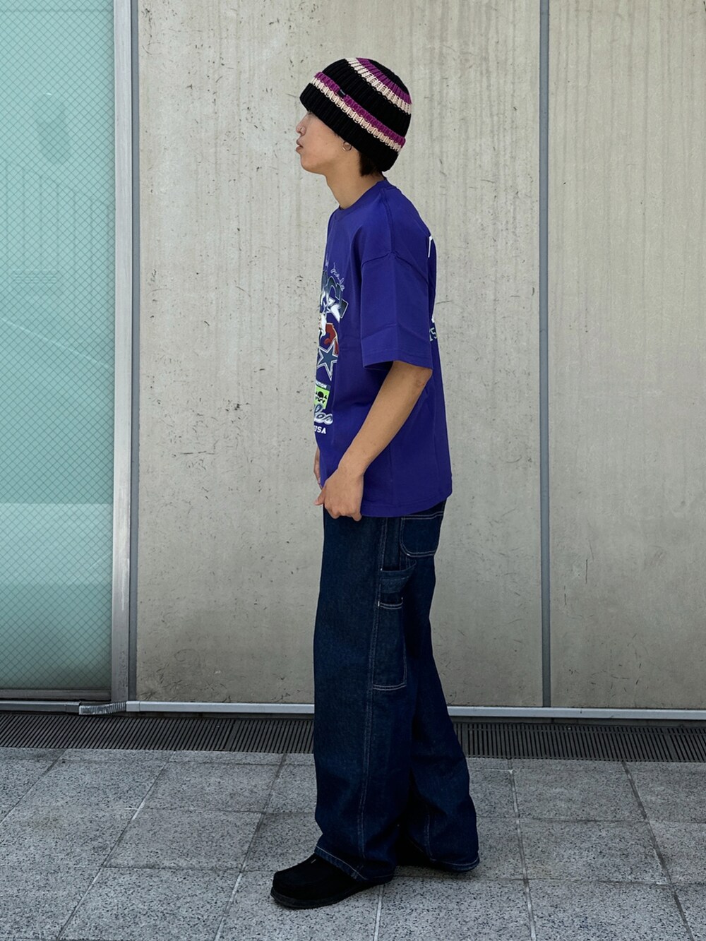 ブルー系のデニムパンツ、パープル系のTシャツ/カットソー、ブラック系のニットキャップ/ビーニーを着用したメンズの春コーディネートの2枚目の写真