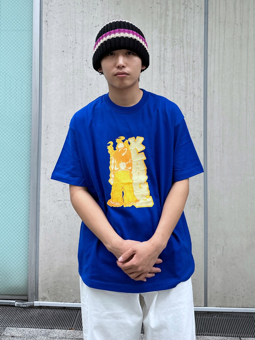 ブルー系のTシャツ/カットソー、ホワイト系のデニムパンツ、ブラック系のニットキャップ/ビーニーを着用したメンズの春コーディネートの5枚目の写真