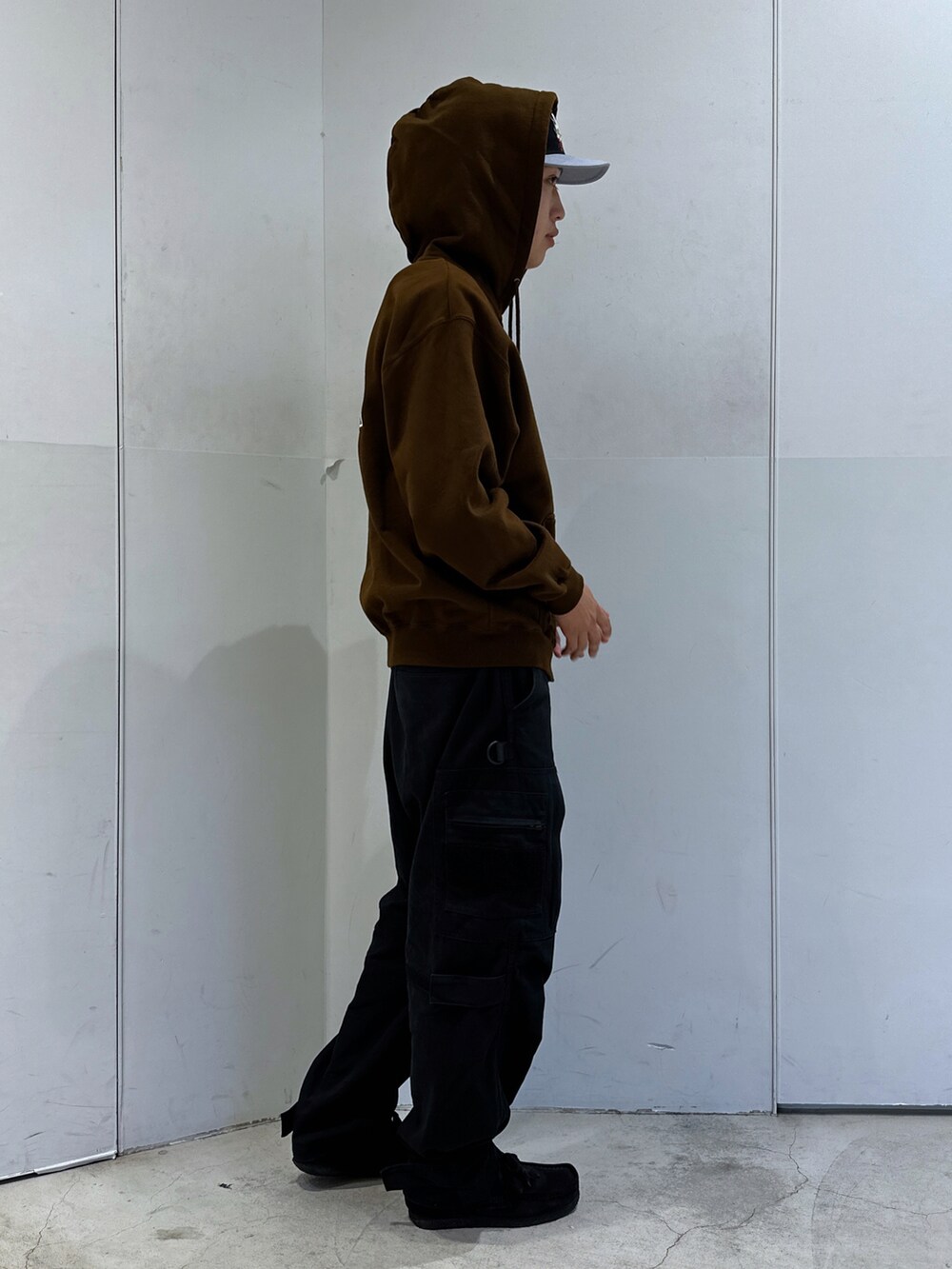 ブラウン系のパーカー、ブラック系のその他パンツ、ブラック系のキャップを着用したメンズの秋コーディネートの4枚目の写真