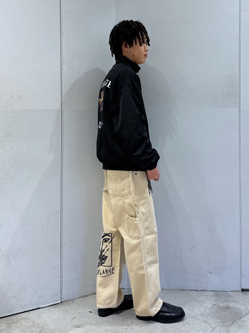 ブラック系のブルゾン、ベージュ系のその他パンツを着用したメンズの冬コーディネートの4枚目の写真