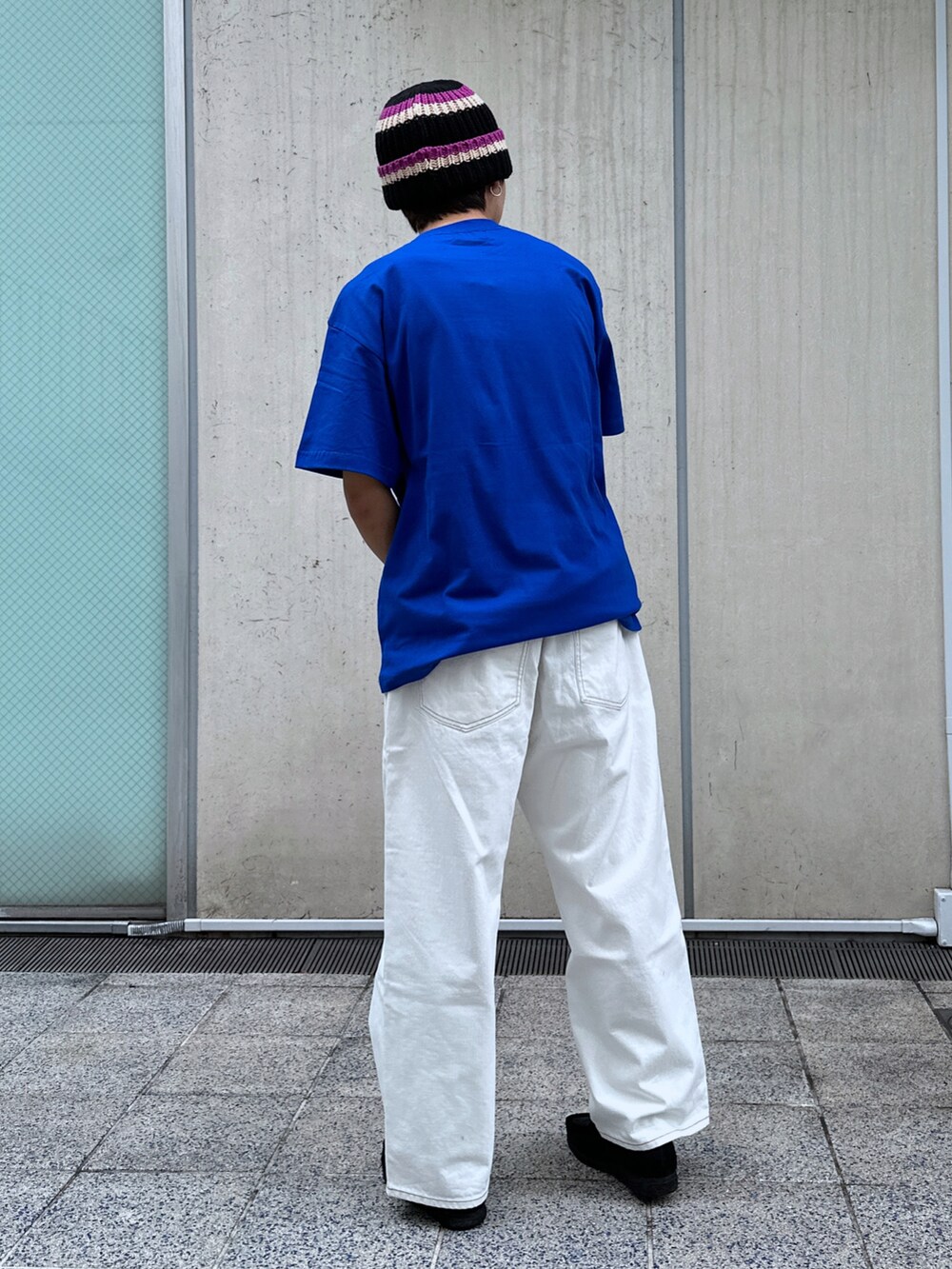 ブルー系のTシャツ/カットソー、ホワイト系のデニムパンツ、ブラック系のニットキャップ/ビーニーを着用したメンズの春コーディネートの3枚目の写真