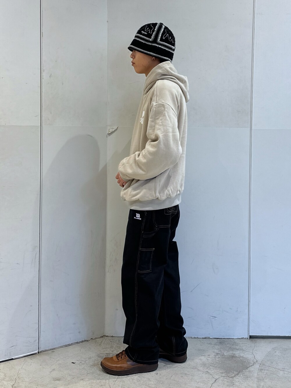 ブラウン系のパーカー、ブラック系のその他パンツ、ブラック系のハットを着用したメンズの冬コーディネートの2枚目の写真