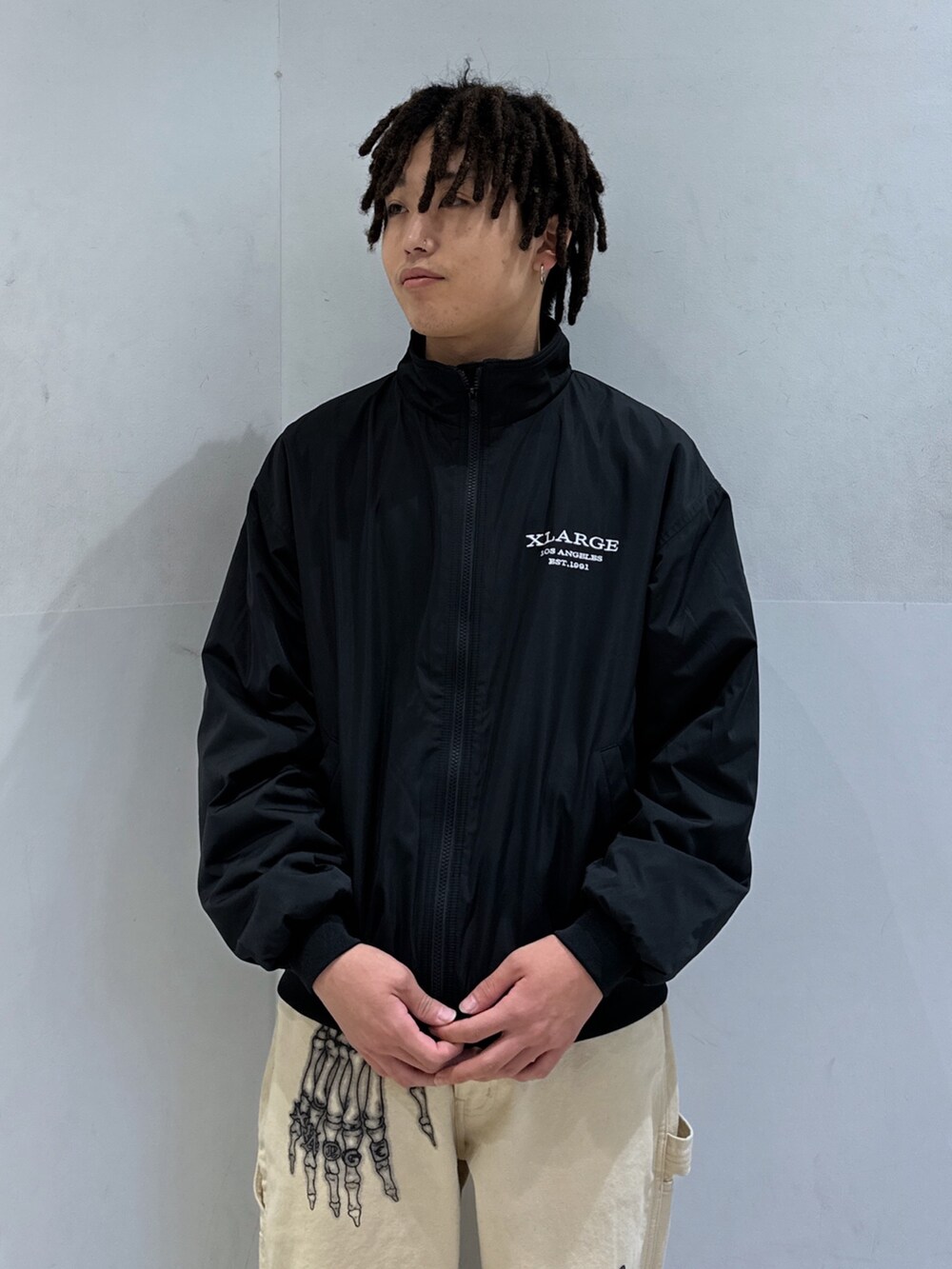 ブラック系のブルゾン、ベージュ系のその他パンツを着用したメンズの冬コーディネートの5枚目の写真