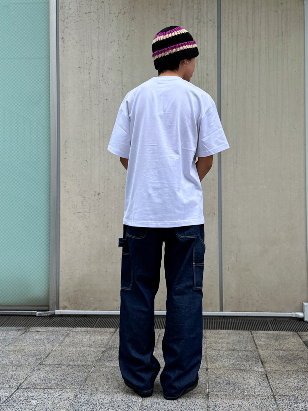 ホワイト系のTシャツ/カットソー、ブルー系のデニムパンツ、ブラック系のニットキャップ/ビーニーを着用したメンズの春コーディネートの3枚目の写真