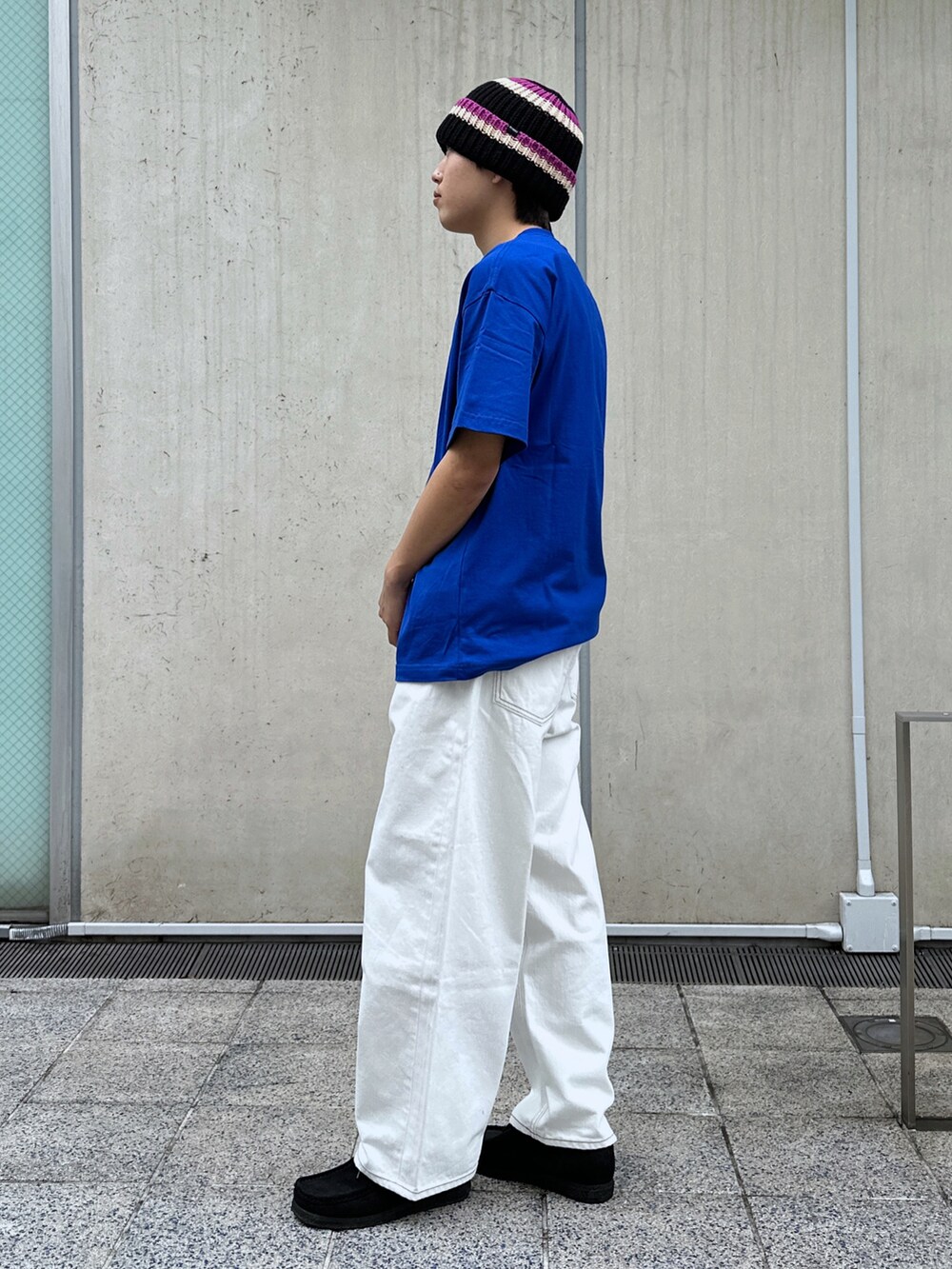 ブルー系のTシャツ/カットソー、ホワイト系のデニムパンツ、ブラック系のニットキャップ/ビーニーを着用したメンズの春コーディネートの2枚目の写真