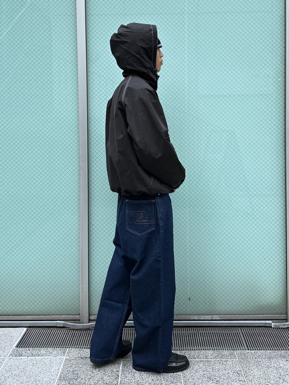 ブラック系のブルゾン、ブルー系のデニムパンツを着用したメンズの冬コーディネートの4枚目の写真