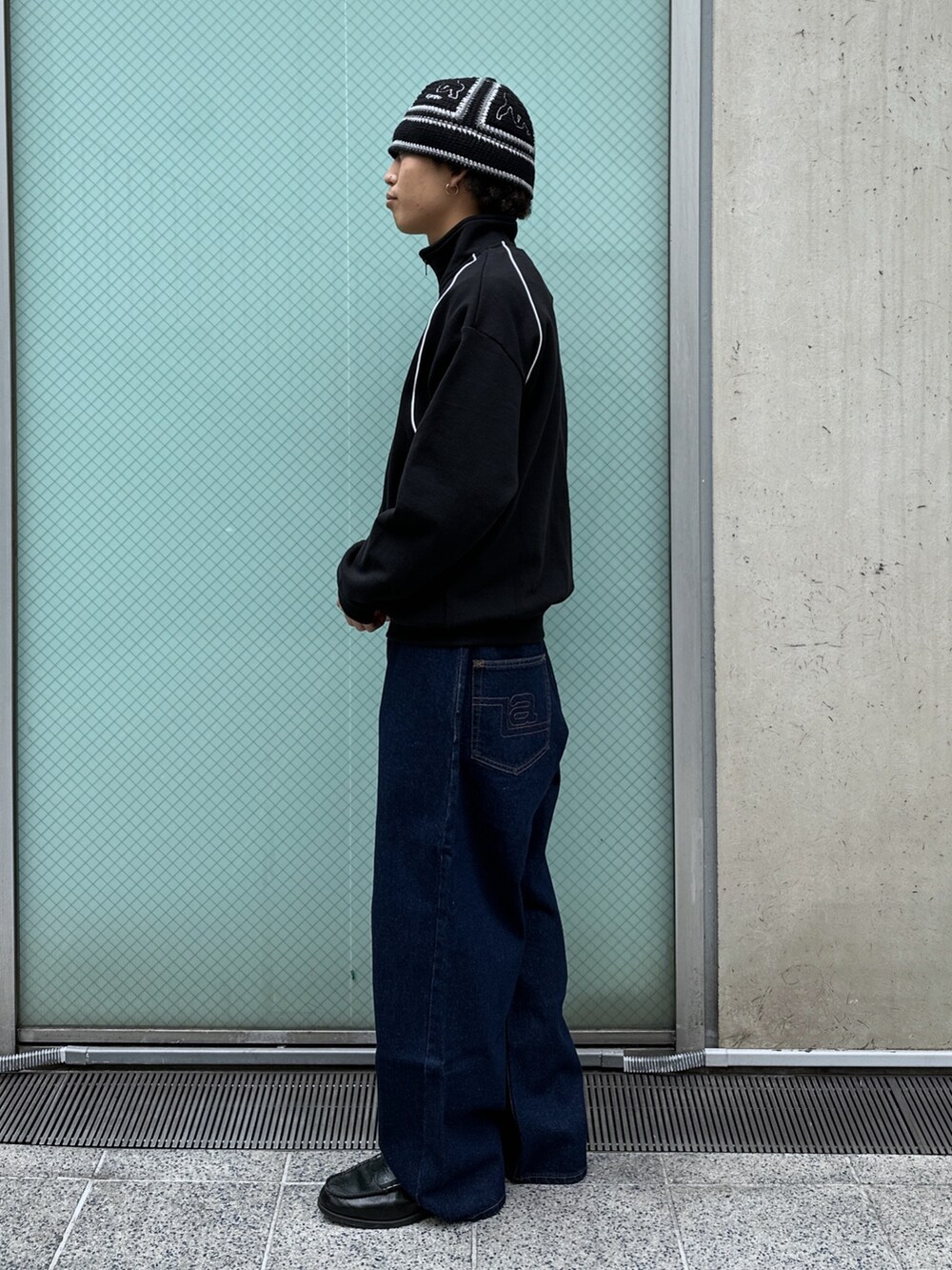 ブラック系のスウェット、ブルー系のデニムパンツを着用したメンズの冬コーディネートの2枚目の写真