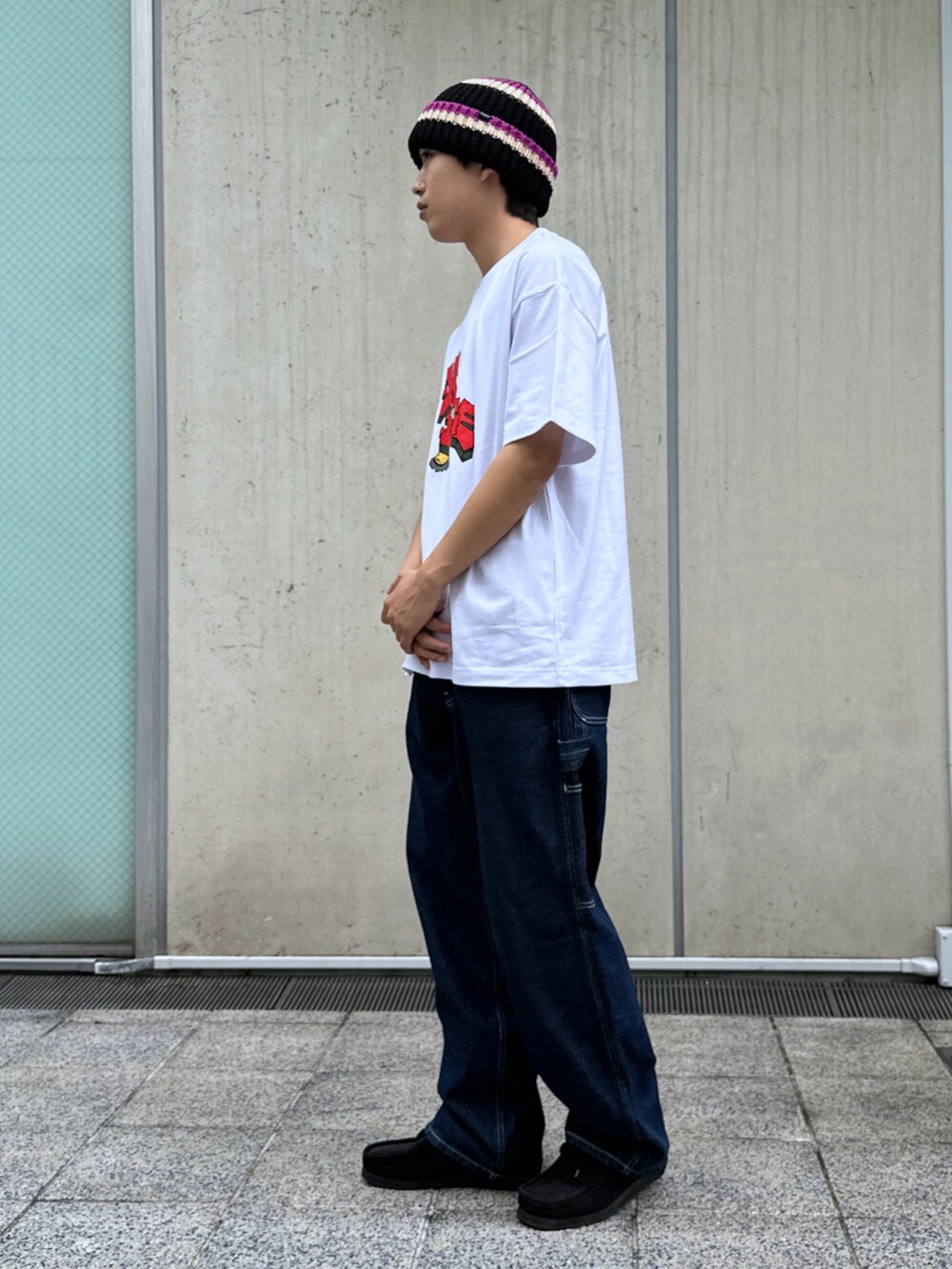 ホワイト系のTシャツ/カットソー、ブルー系のデニムパンツ、ブラック系のニットキャップ/ビーニーを着用したメンズの春コーディネートの2枚目の写真