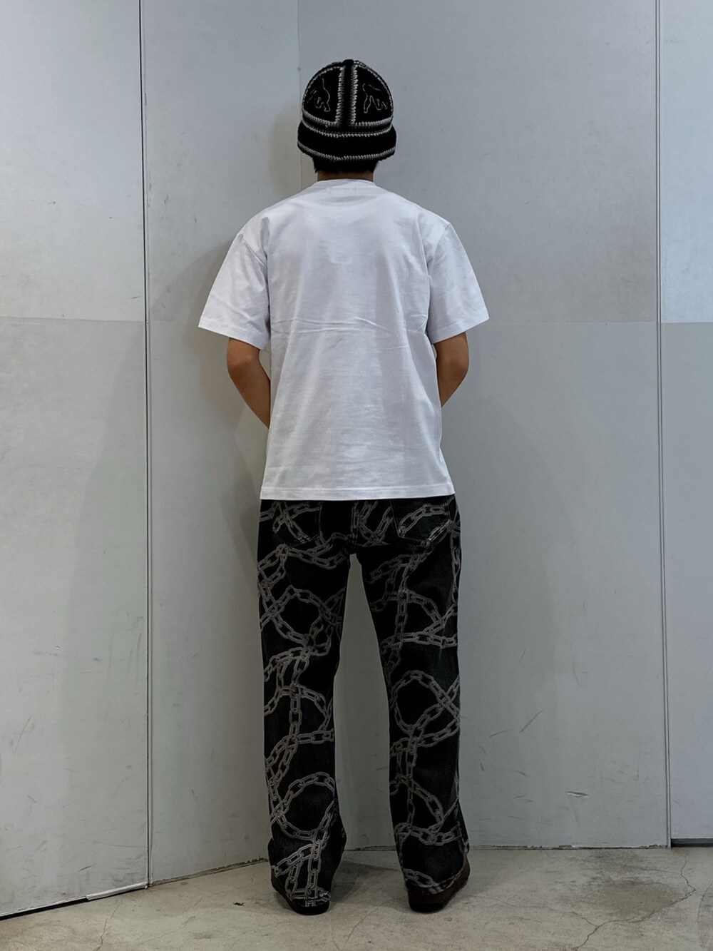 ホワイト系のTシャツ/カットソー、ブラック系のデニムパンツ、ブラック系のハットを着用したメンズの春コーディネートの3枚目の写真